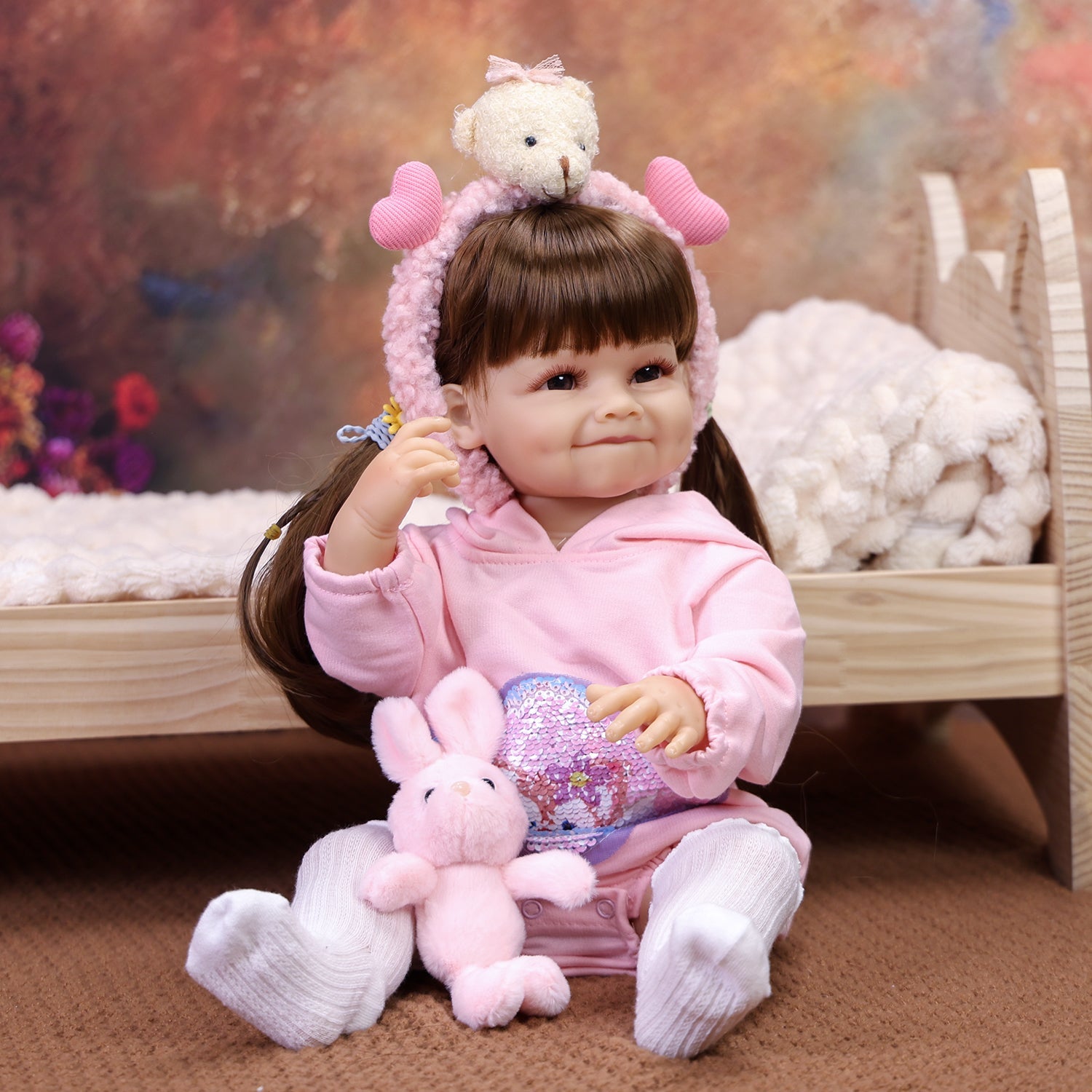 KEIUMI Giggles reborn doll with a dimpled smile in a pink romper.