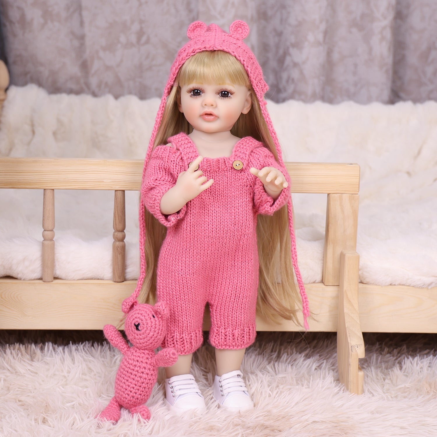 KEIUMI Maisie toddler doll with pink knitted outfit and bear toy.