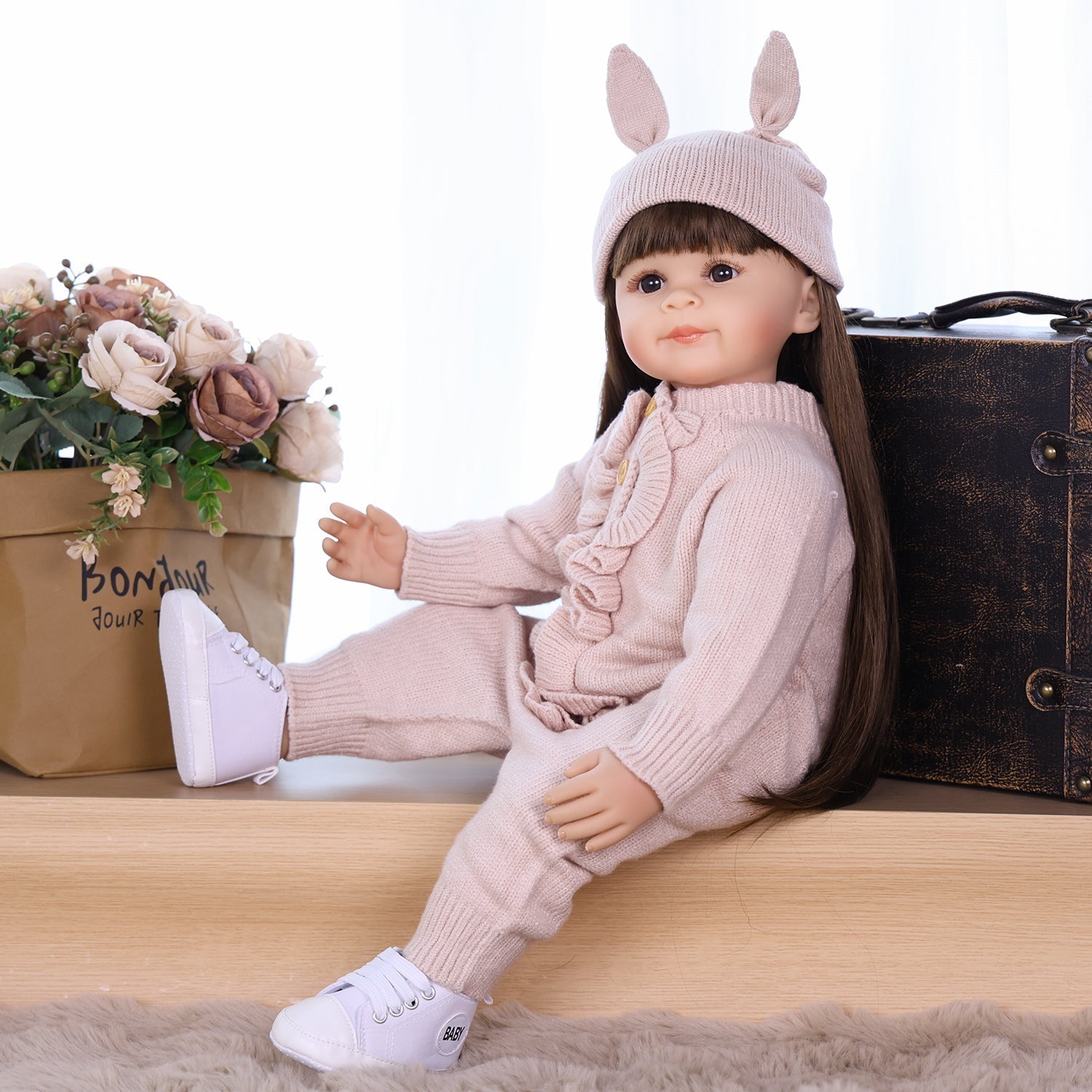 Poppy silicone reborn doll in pink outfit with bunny hat
