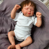 Full view of KEIUMI Tender Slumber reborn doll sleeping in white onesie.