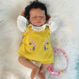 Side profile of the lifelike reborn doll's sleeping face and dark hair.