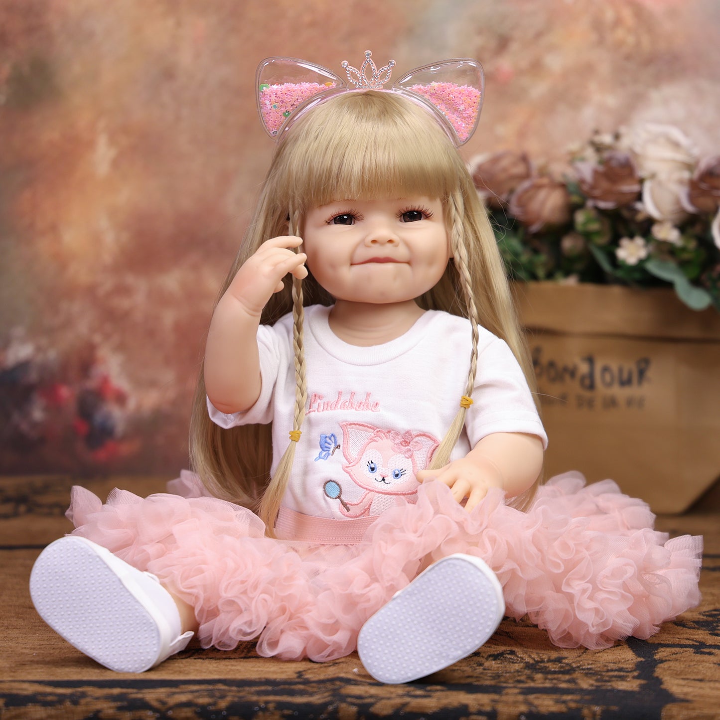 Close-up of KEIUMI reborn doll's smiling face with dimples and brown eyes.