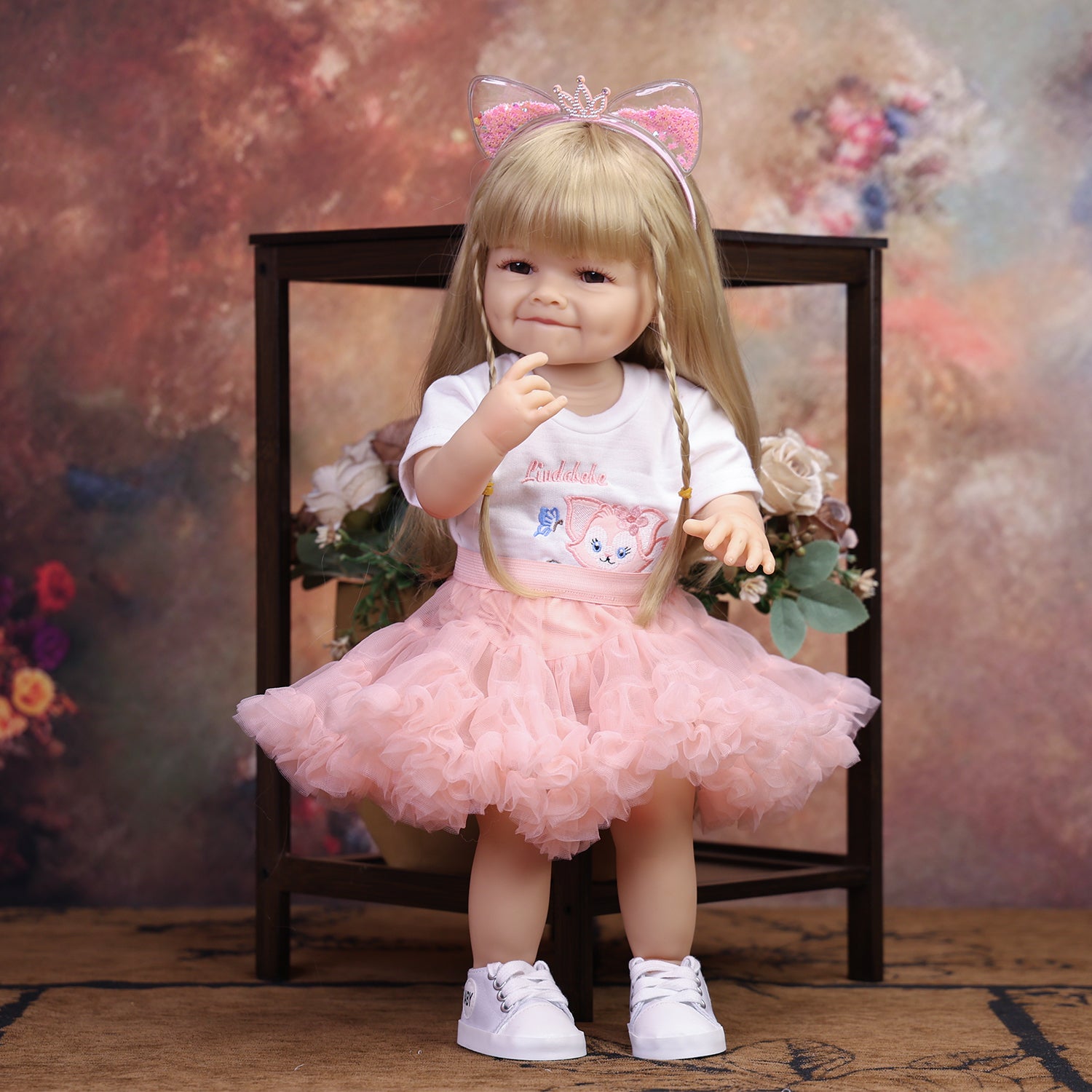 Reborn doll's blonde hair and pink glitter cat ear headband with silver crown.