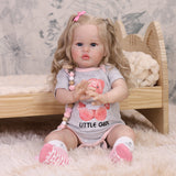 Full view of Penny reborn doll with all accessories, including bottle and teddy.