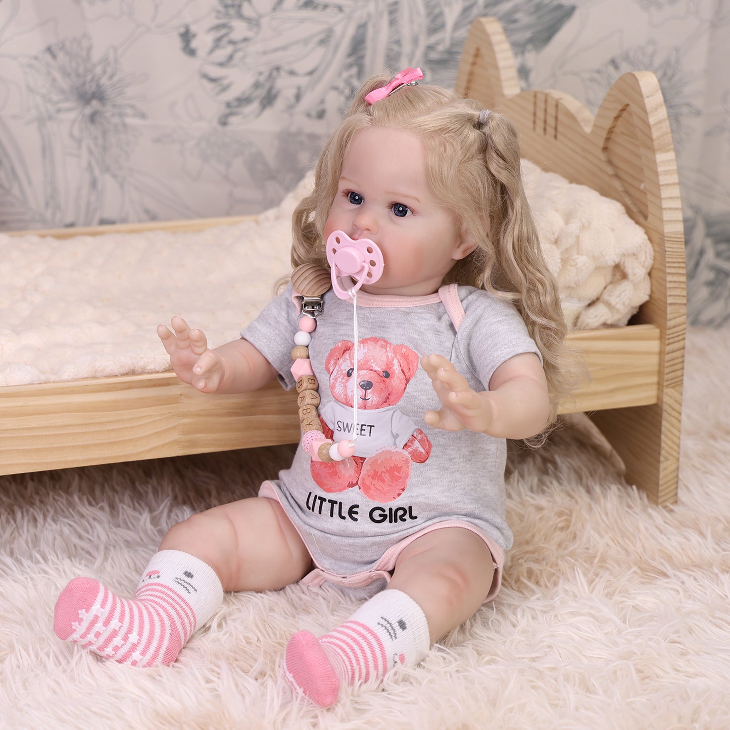 Penny reborn doll's blonde pigtails with pink bows and realistic hair texture.