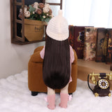 KEIUMI Elara reborn toddler doll with long dark hair, wearing pink knitted romper.