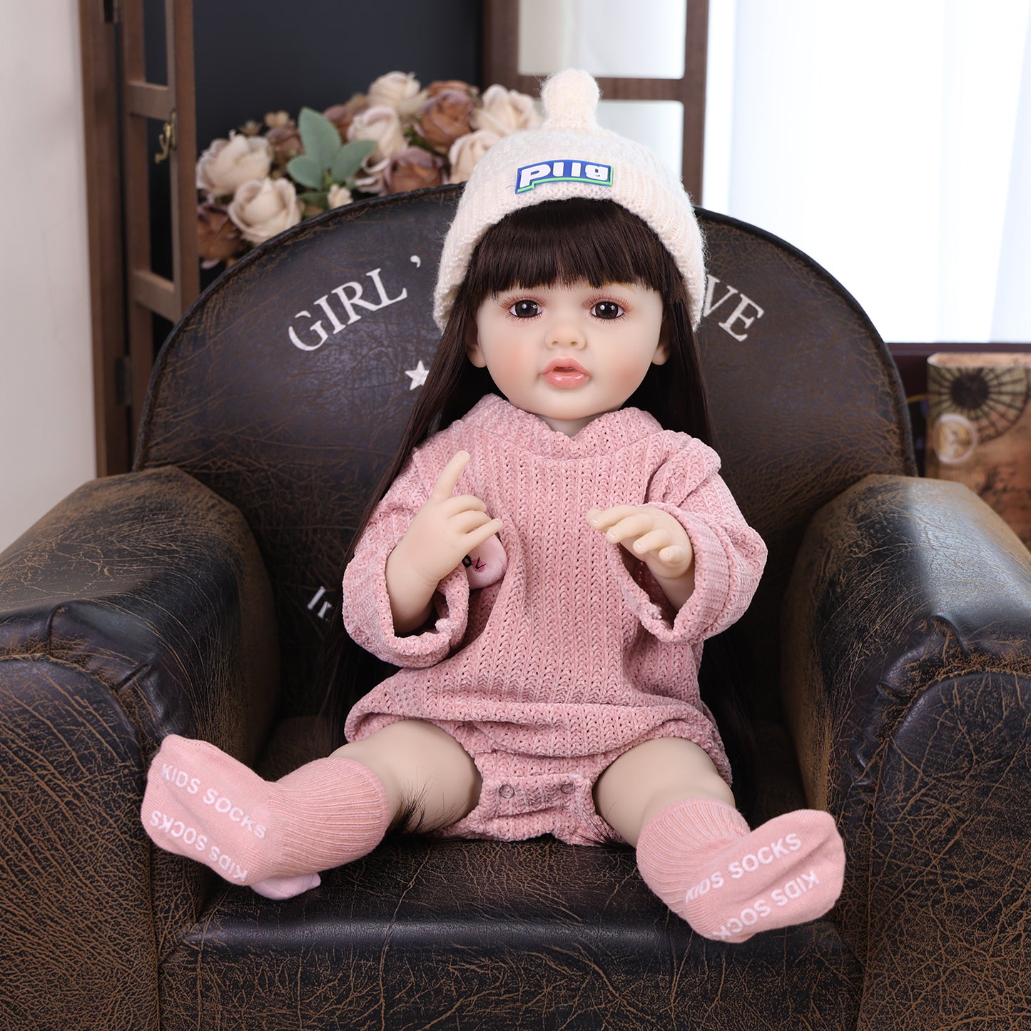 Elara reborn doll holding her clear baby bottle with a pink cap.