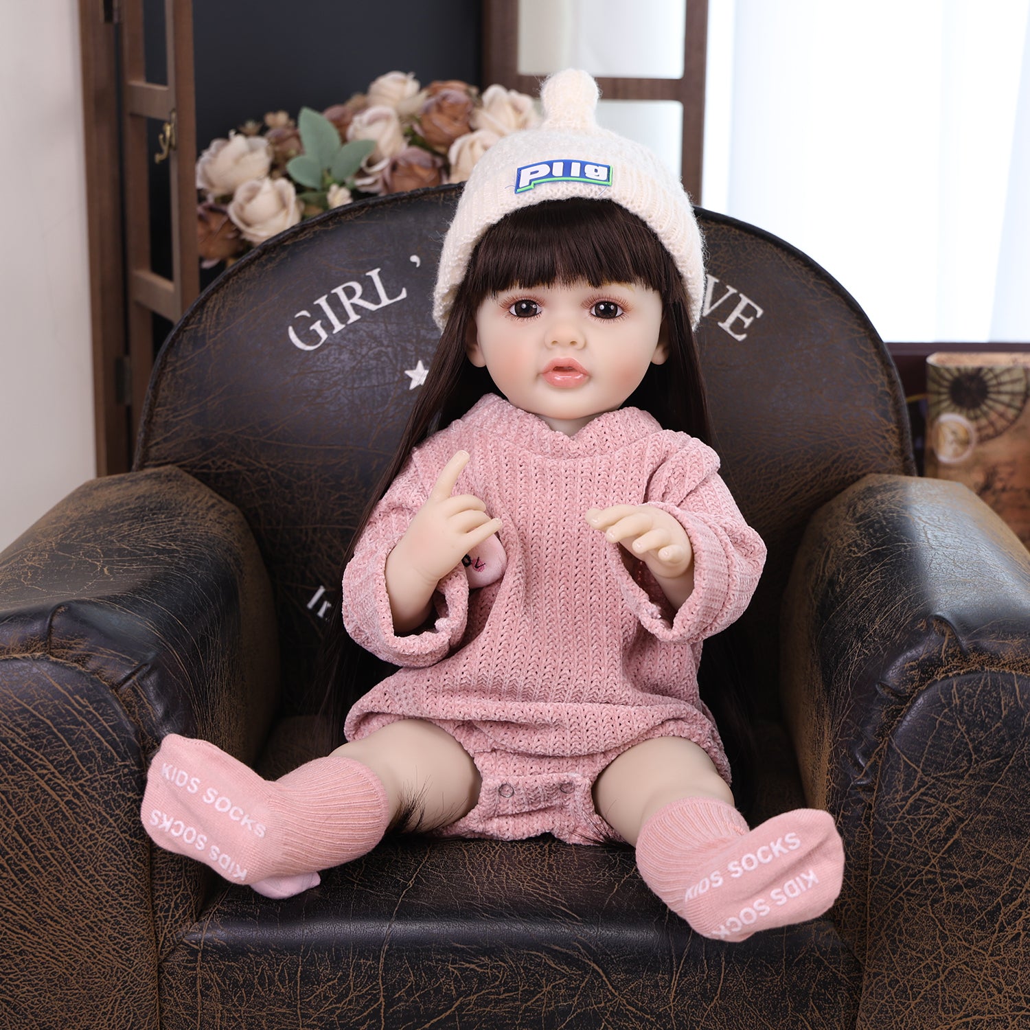 Elara reborn doll holding her clear baby bottle with a pink cap.