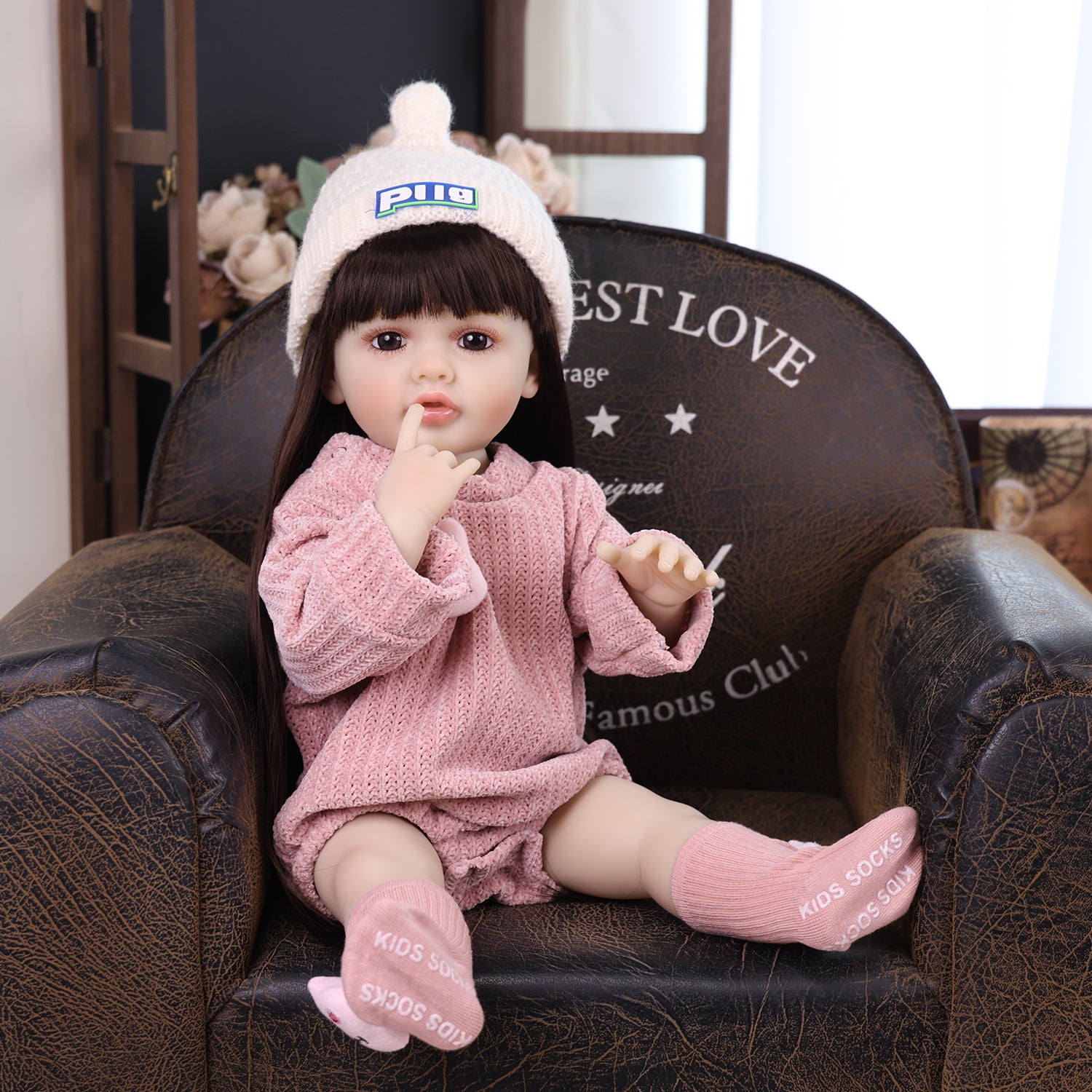 Full body shot of Elara in her knitted outfit, with pacifier and bottle.