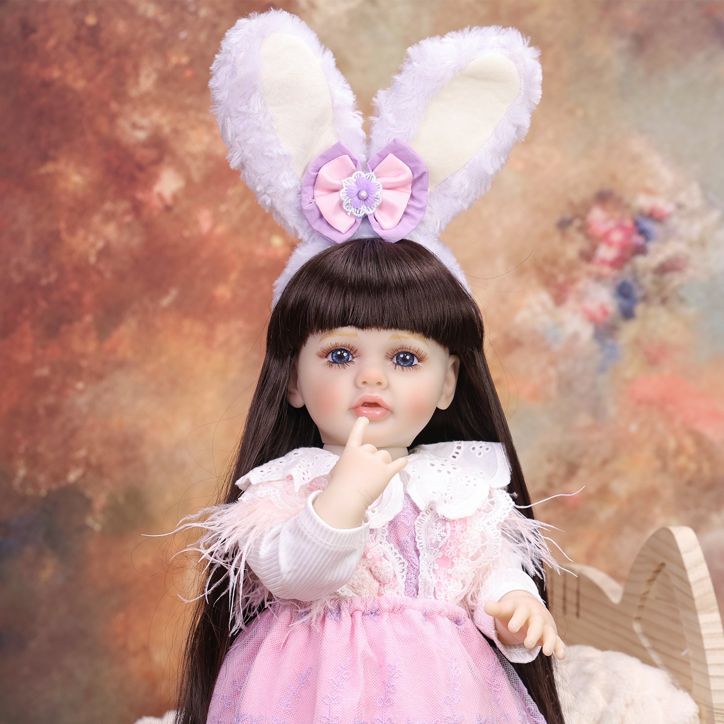 KEIUMI Primrose doll sitting, showing pink and lavender layered outfit.