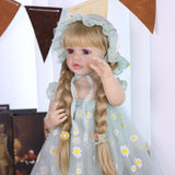 Lifelike silicone reborn doll wearing a mint green daisy outfit and bonnet.