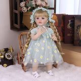 Side profile of the reborn doll, highlighting her blonde braids and bonnet.
