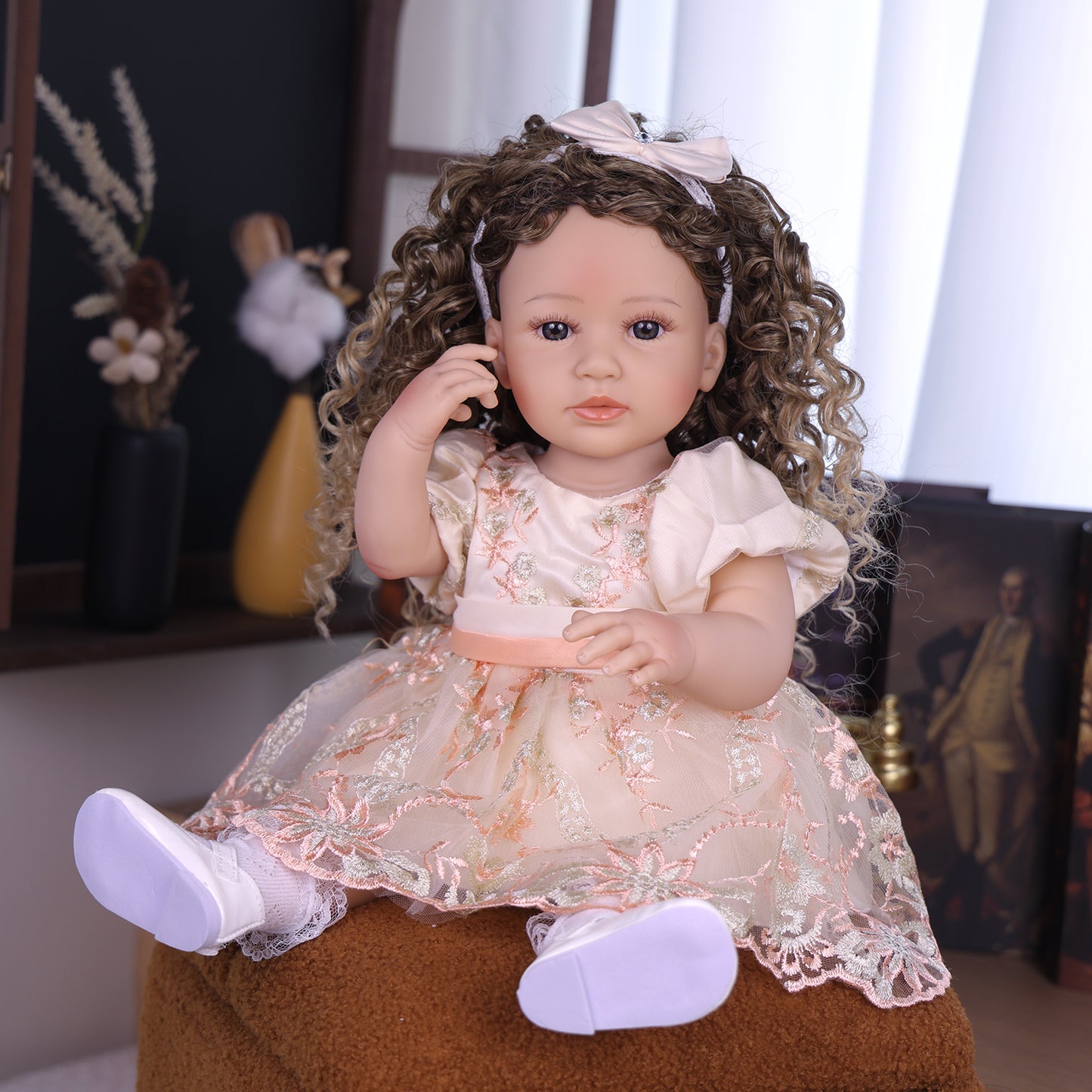 KEIUMI Emmeline reborn toddler doll with blue eyes and curly hair in embroidered dress.
