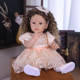 Close-up of Emmeline reborn doll's sweet face, blue eyes, and cream bow headband.