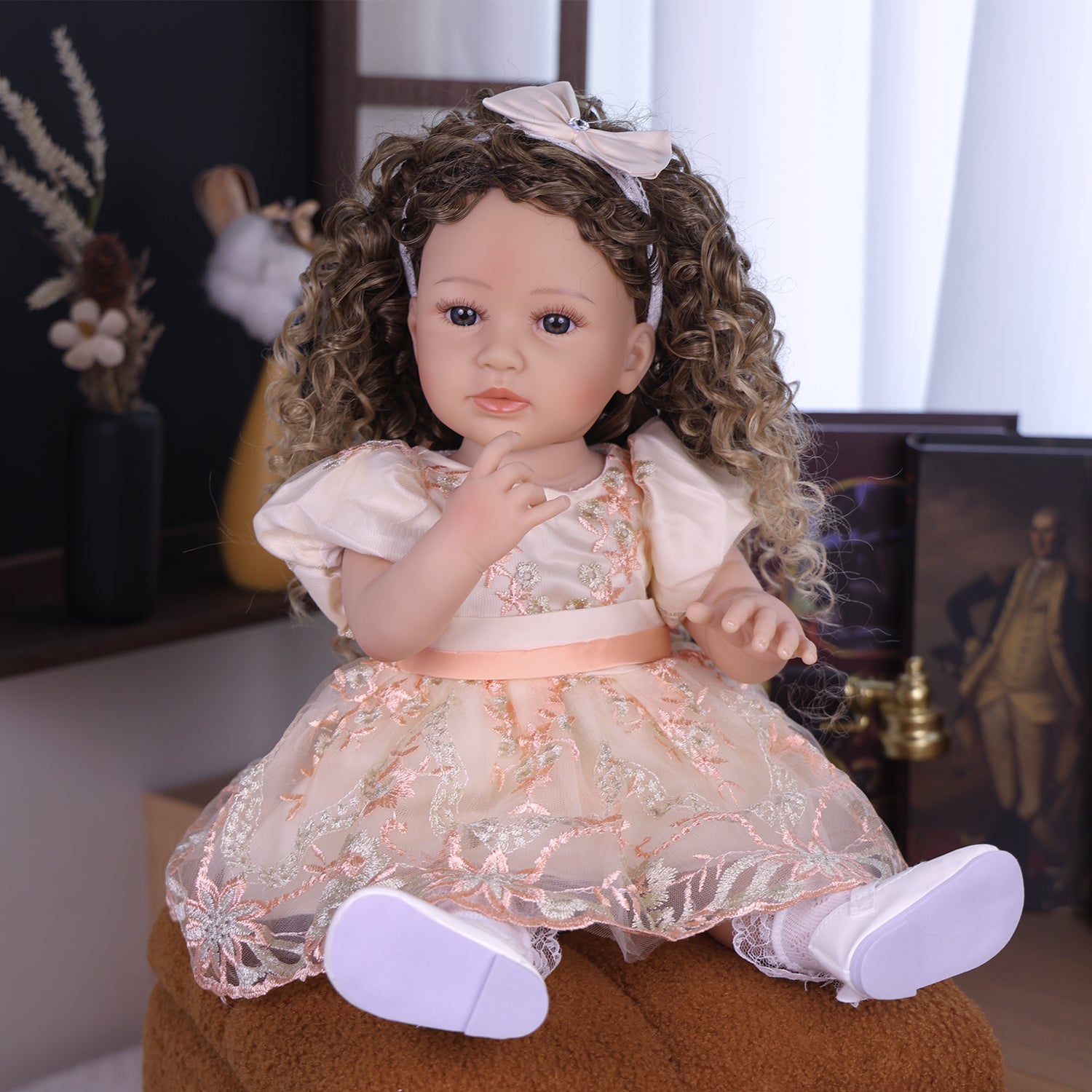 Close-up of Emmeline reborn doll's sweet face, blue eyes, and cream bow headband.