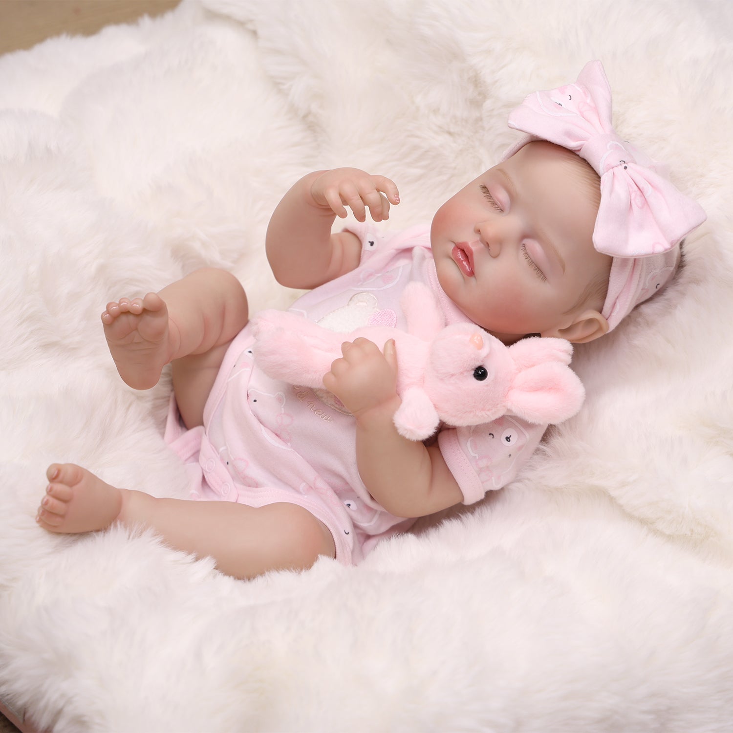 Sleeping reborn doll's face, highlighting rosy cheeks and delicate features.