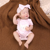 Reborn doll's profile, emphasizing the pink bow and peaceful sleep.