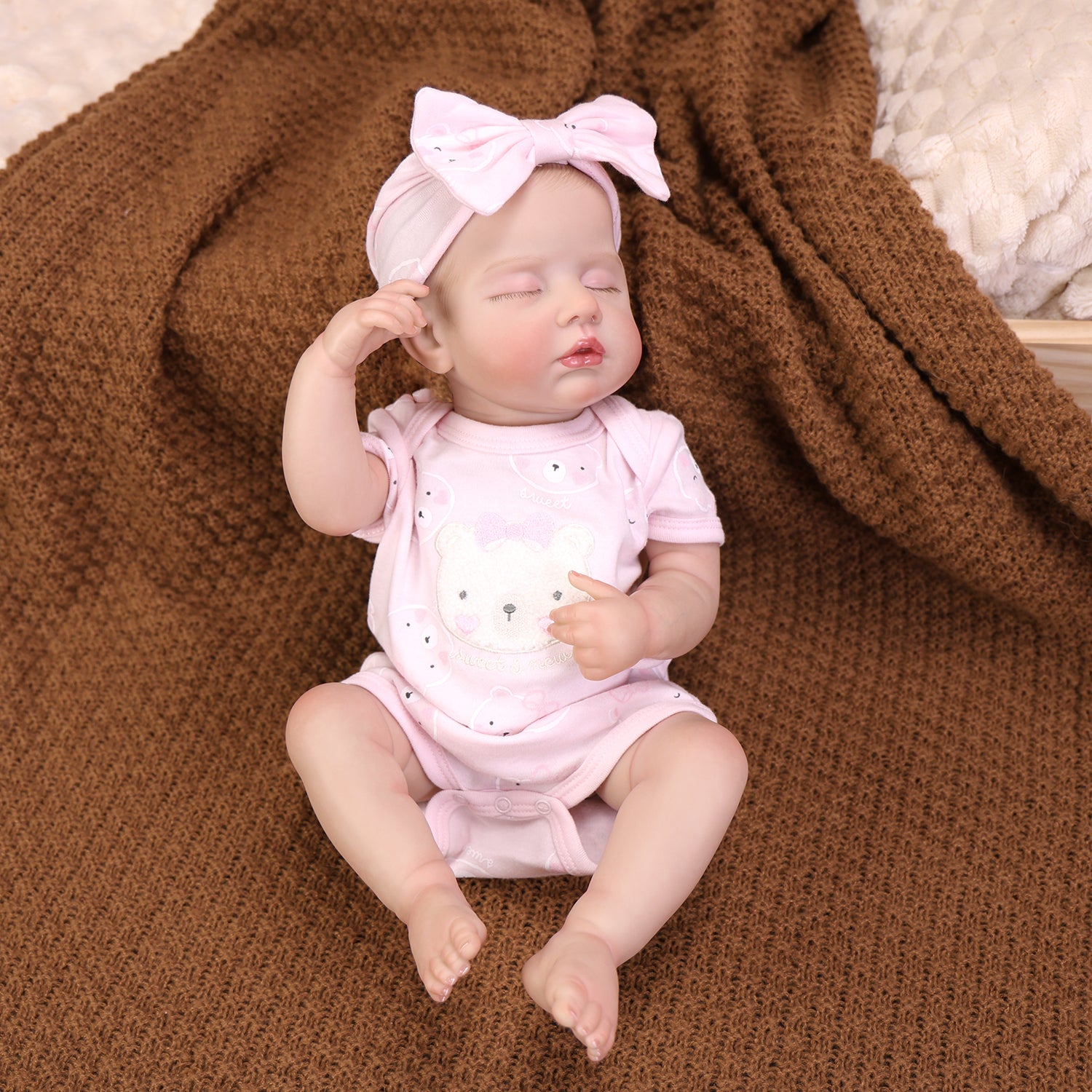 Reborn doll's profile, emphasizing the pink bow and peaceful sleep.