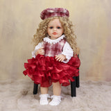 KEIUMI Curious Belle reborn doll in plaid dress, showing her golden curls.