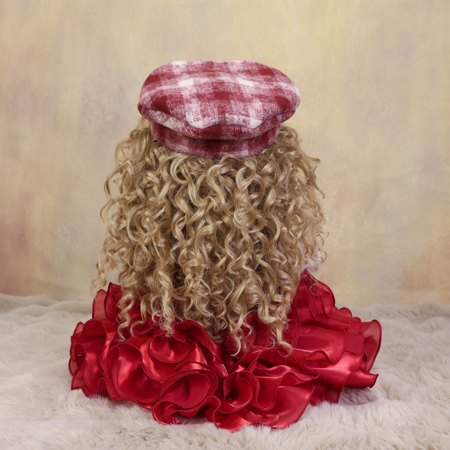 Curious Belle doll with pink pacifier, dressed in her charming plaid pinafore.
