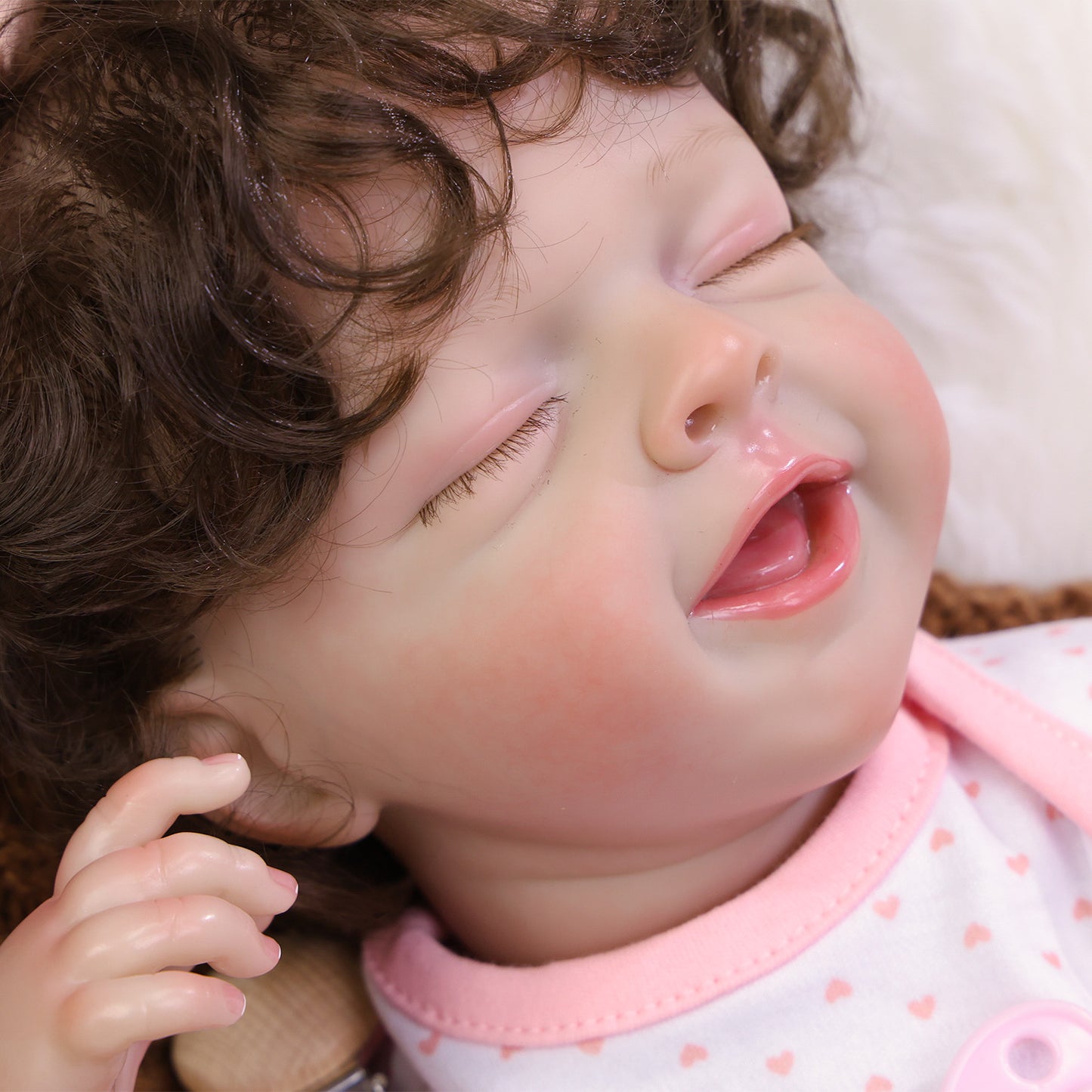 Full body view of Rosalie sleeping, showing her outfit and 'BABY' pacifier clip.