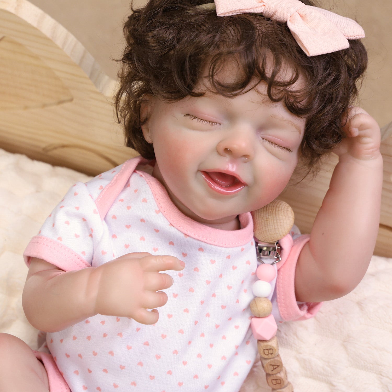 Rosalie's delicate hand holding the pink pacifier, showing realistic skin folds.