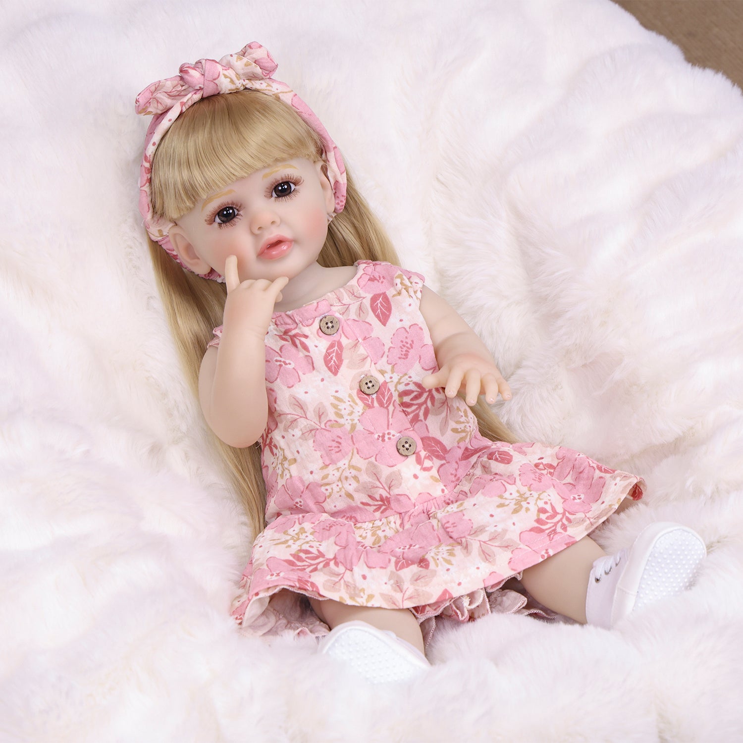 KEIUMI Posy reborn doll with blonde hair and pink floral dress.