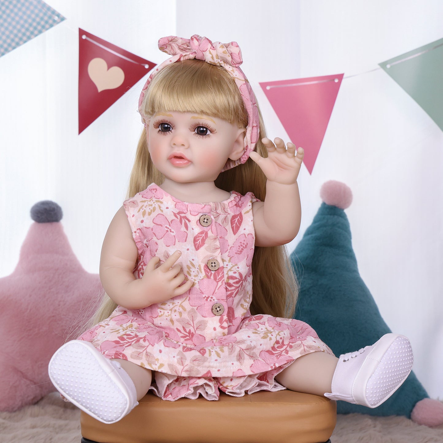 Posy reborn doll in her full floral dress and white canvas shoes.