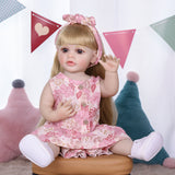 Posy reborn doll in her full floral dress and white canvas shoes.