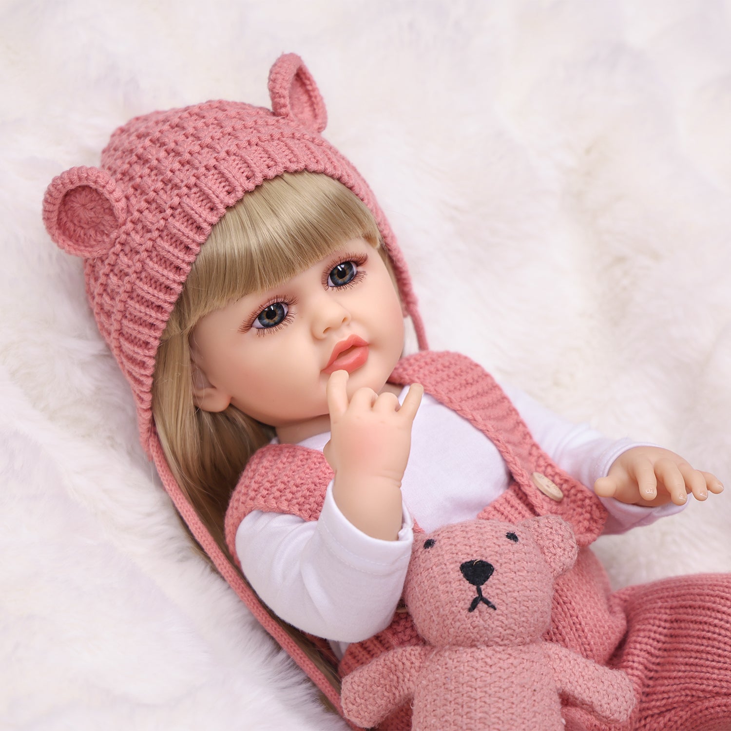KEIUMI Blossom reborn doll in pink knitted outfit, front view.