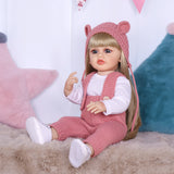 Blossom reborn doll lying down, holding her matching pink knitted teddy bear.