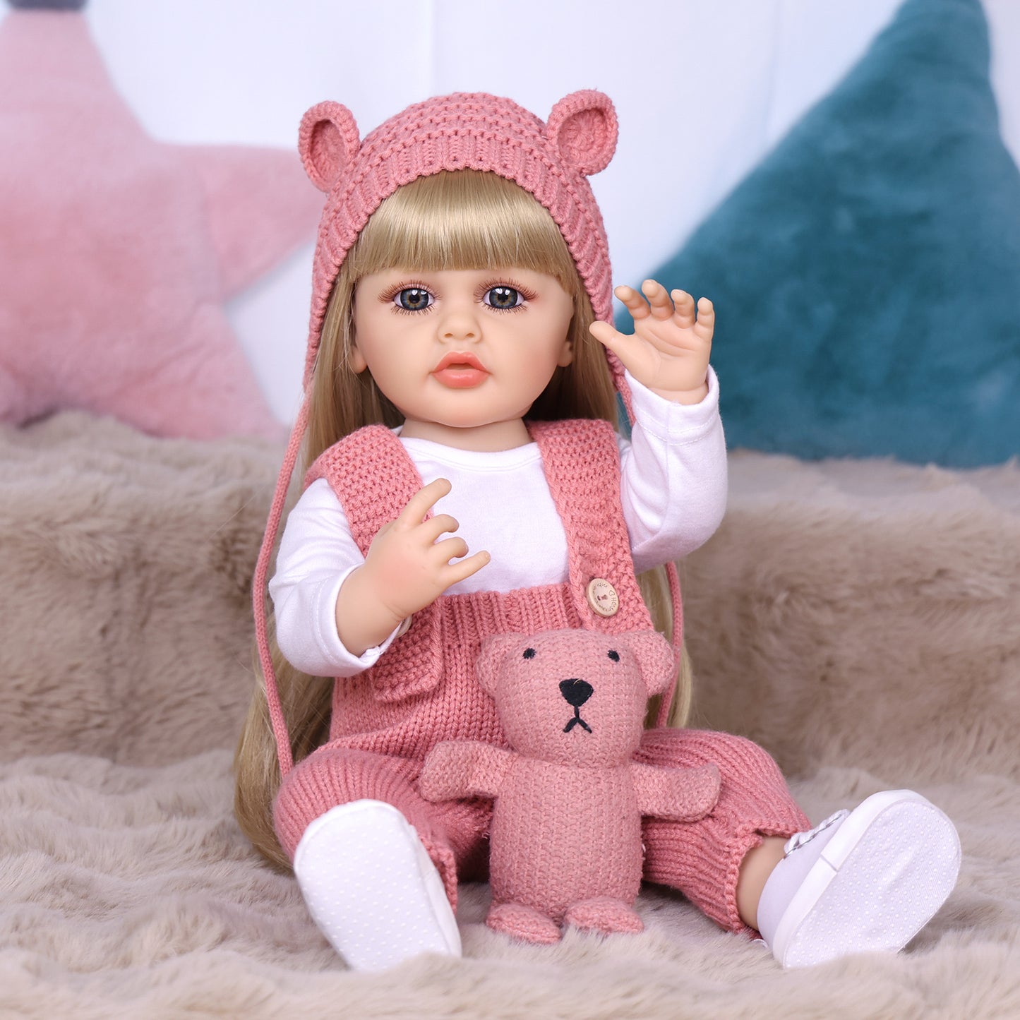 Full body view of Blossom reborn doll in pink knitted outfit with teddy.