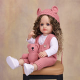 Close-up of Sweetpea reborn doll's face, showing hazel eyes and light brown hair.