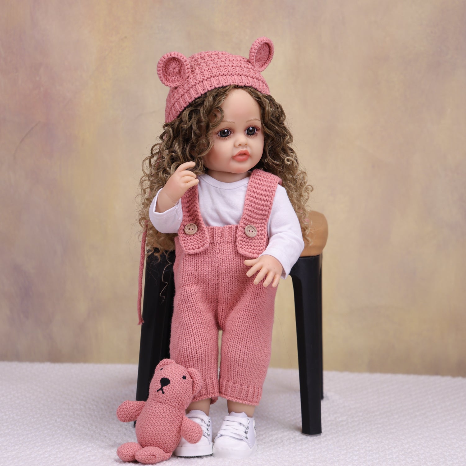 Full body view of KEIUMI Sweetpea doll in pink knitted outfit and white sneakers.
