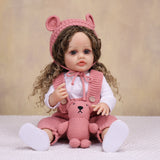 Side profile of realistic reborn doll, showcasing curly light brown hair.
