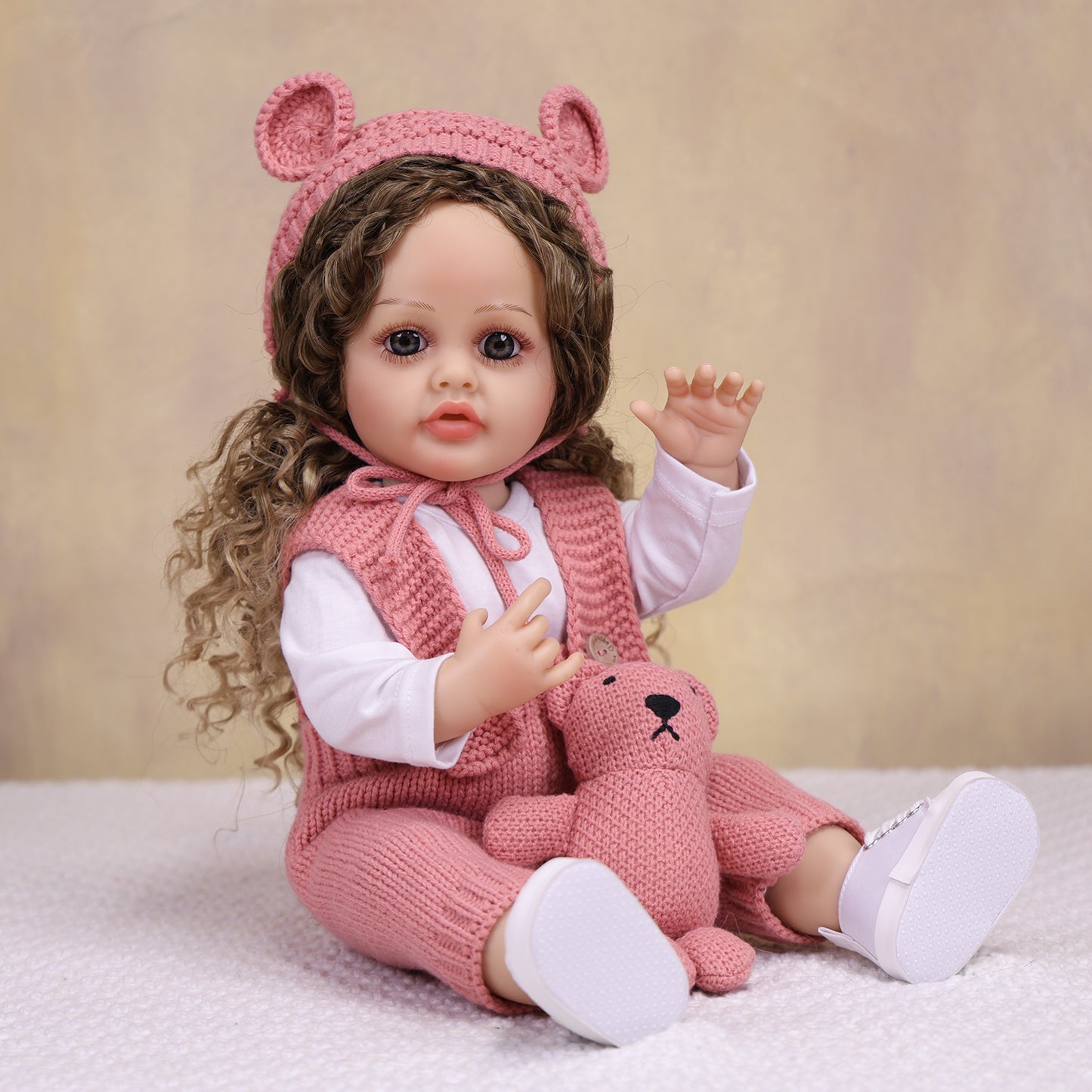 Sweetpea reborn doll with baby bottle, dressed in cozy knitted ensemble.