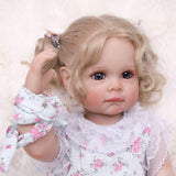 KEIUMI Pippa reborn doll with blonde pigtails, blue eyes, and floral romper.