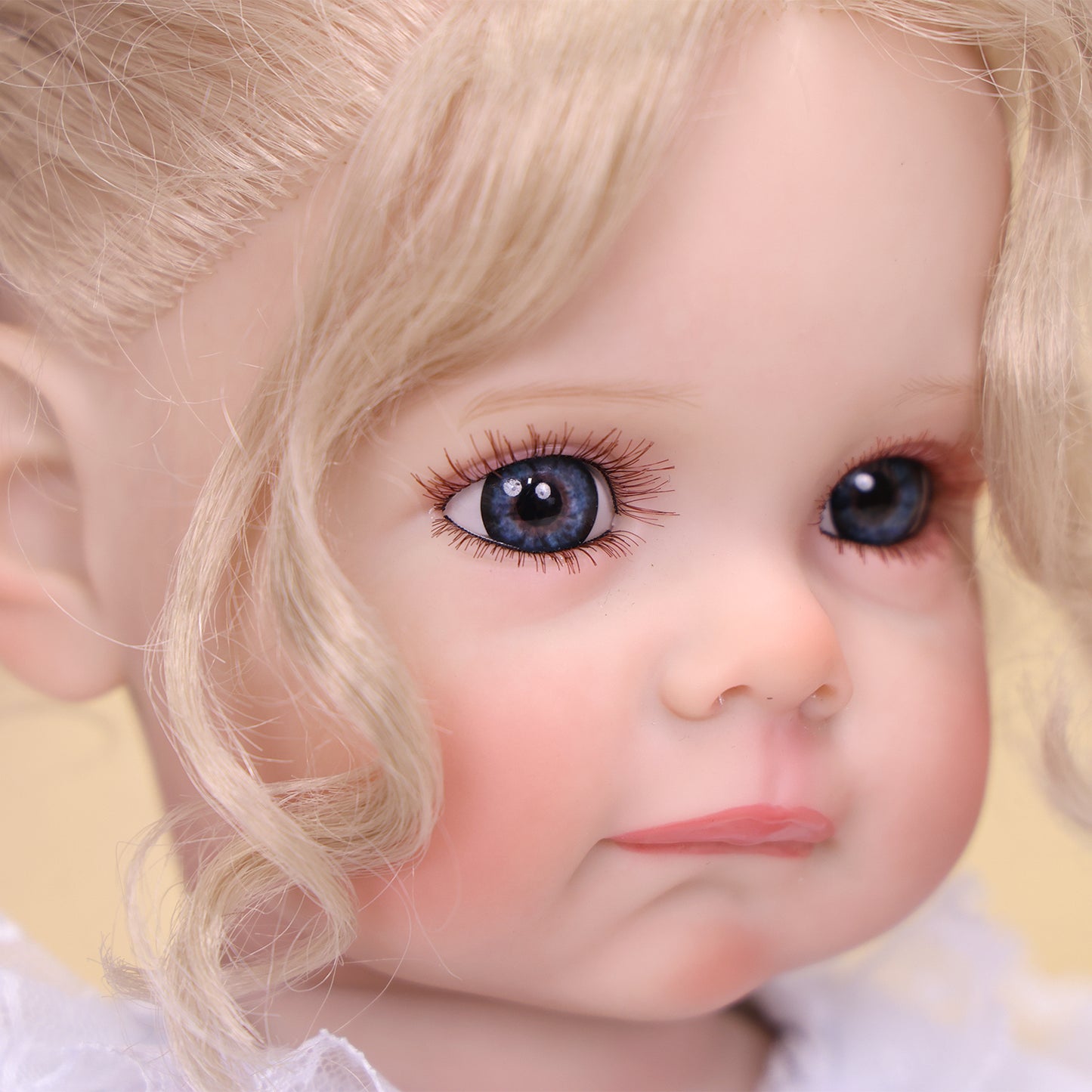 Pippa reborn doll holding her pink pacifier, with a gentle, pouting expression.