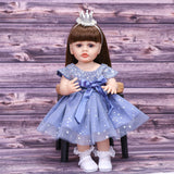 Aurora reborn doll holding a pink pacifier, dressed in her princess outfit.