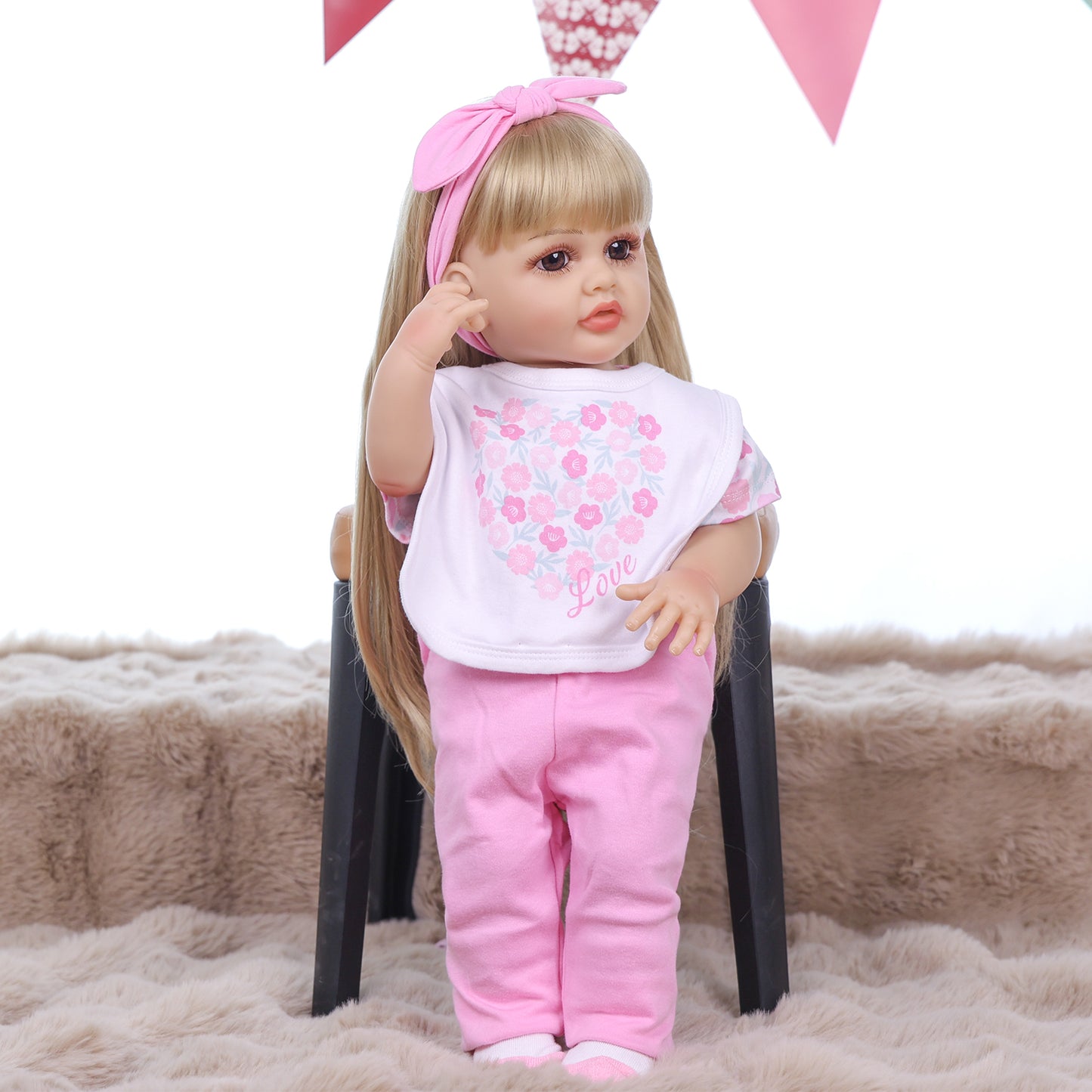 Joy reborn doll holding baby bottle, wearing pink floral bodysuit.
