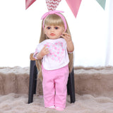 KEIUMI Joy doll's feet in white socks with pink accents, holding pacifier.