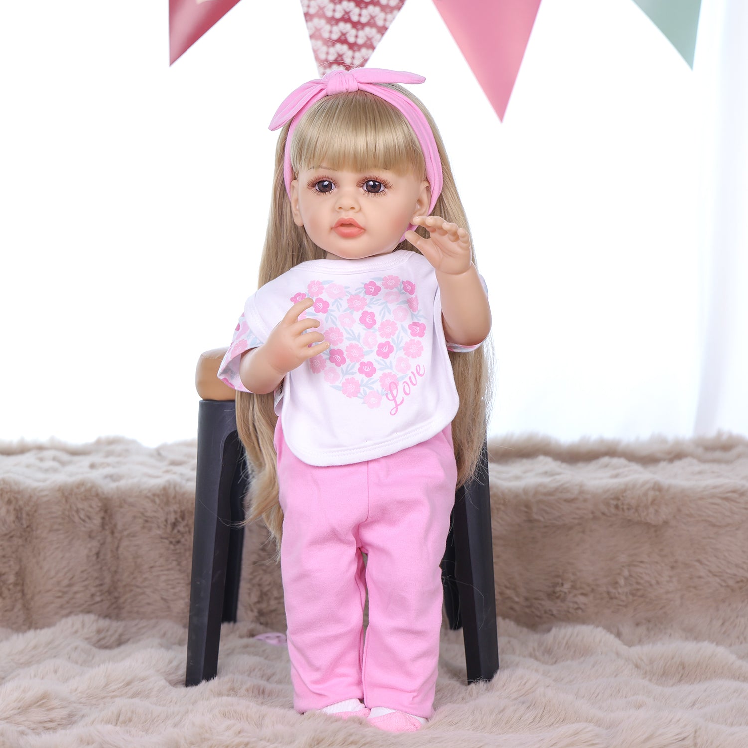 KEIUMI Joy doll's feet in white socks with pink accents, holding pacifier.