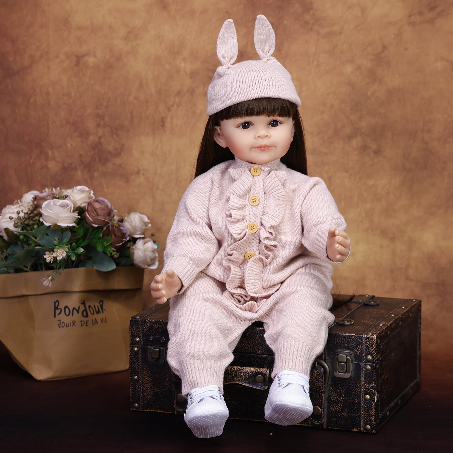Side profile of Poppy reborn doll, highlighting her long dark brown hair.