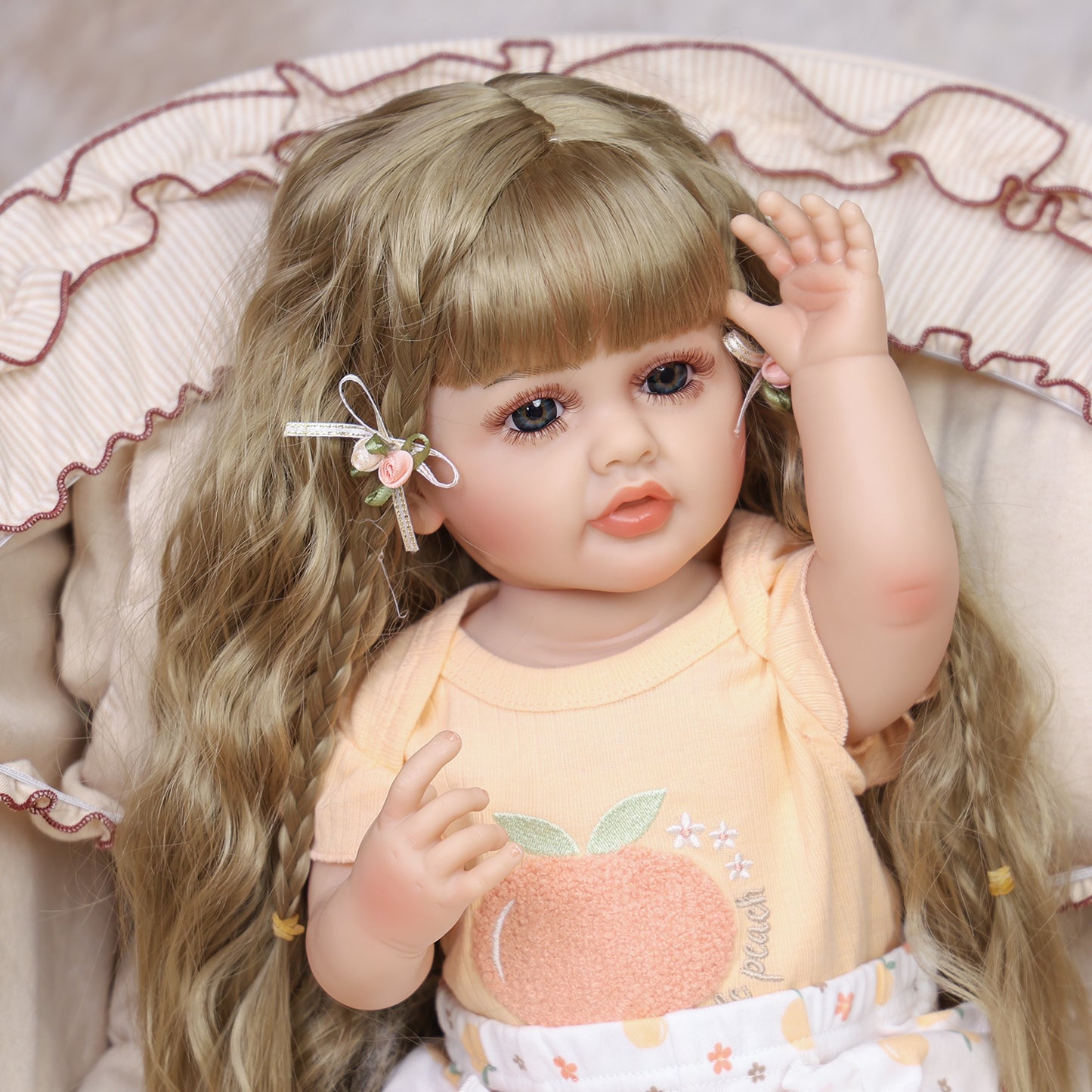 Close-up of Peaches reborn doll's face, showing neutral expression and blue eyes.