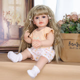 KEIUMI Peaches doll holding her pink pacifier, dressed in peach outfit.
