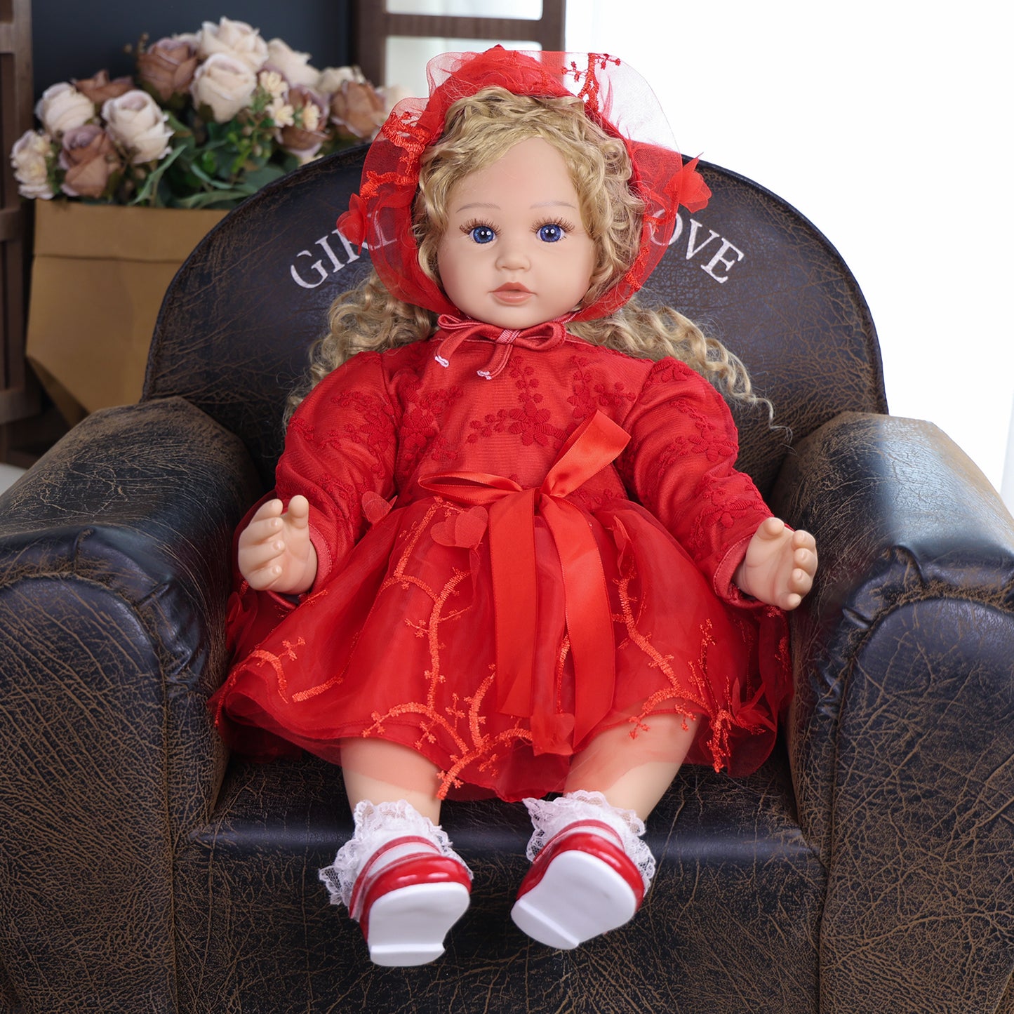 KEIUMI Ruby Belle reborn doll with blonde curls and blue eyes in red dress.