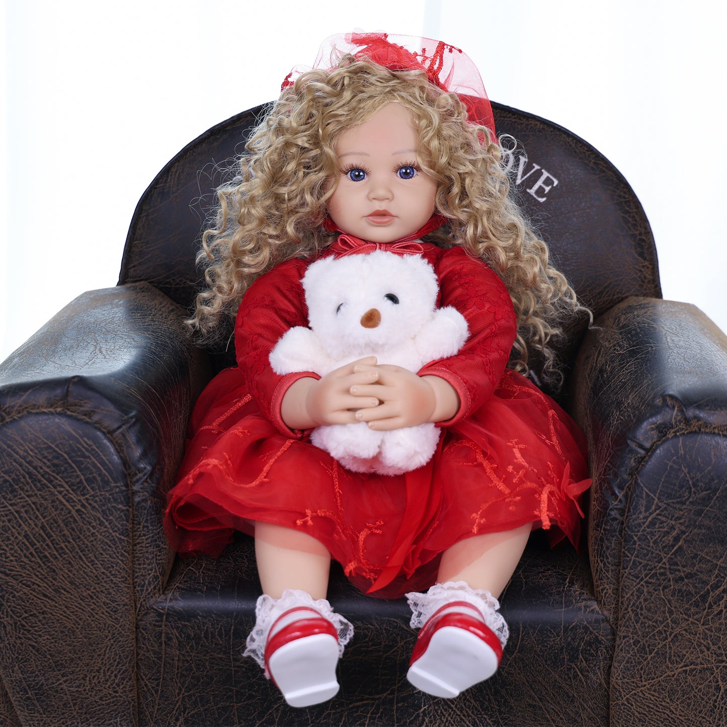 Side profile of Ruby Belle reborn doll, highlighting golden blonde curls and bonnet.
